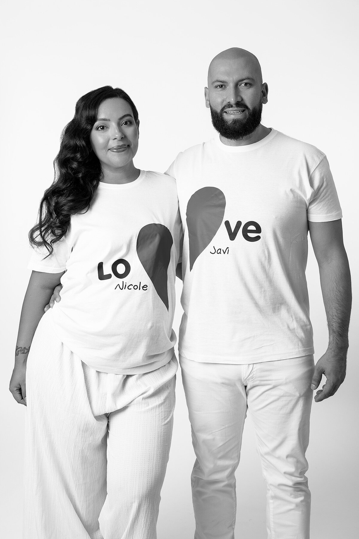 Pareja vestida de blanco en sesión de maternidad